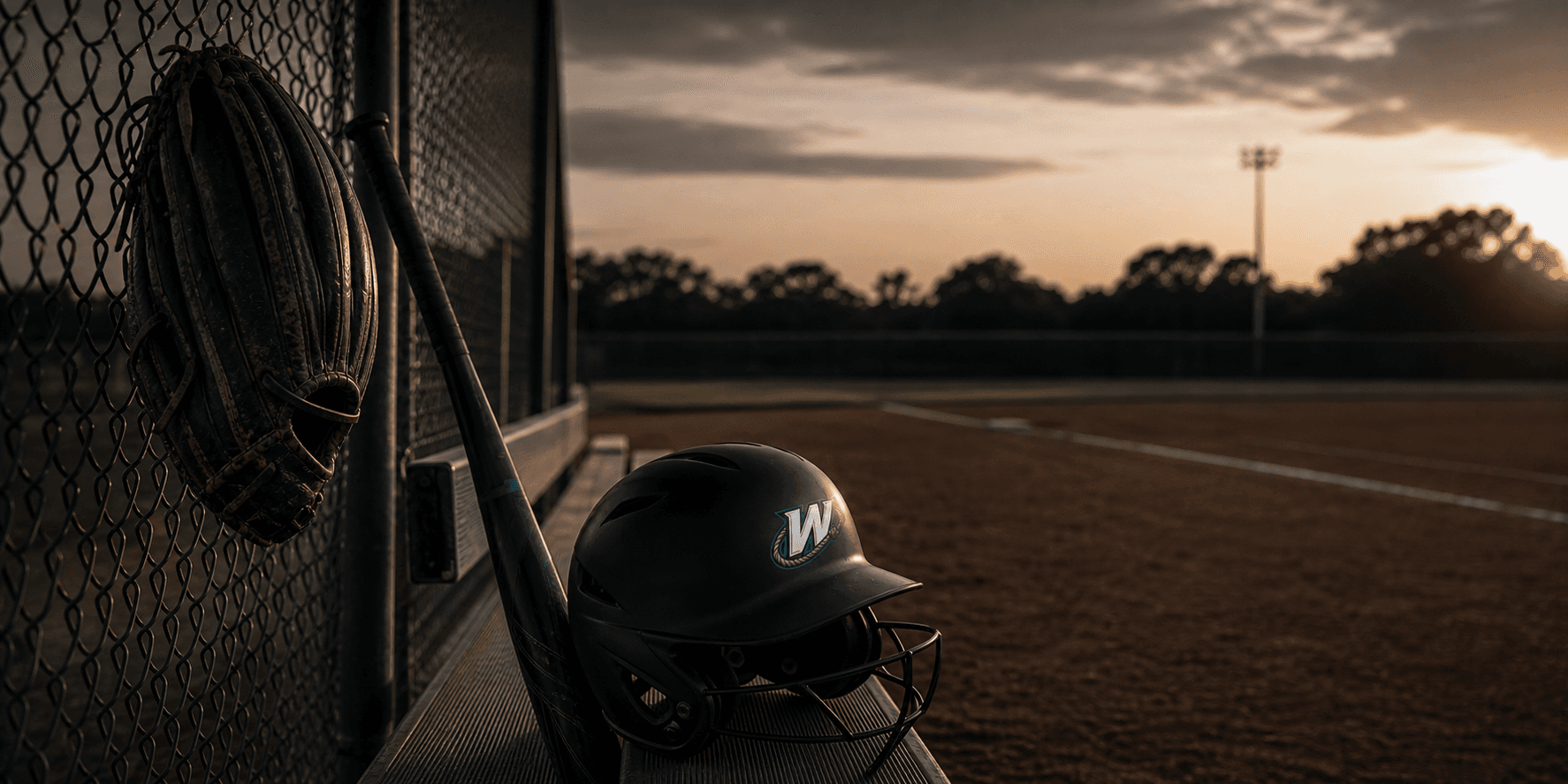 Softball gear hanging in a dugout at golden hour